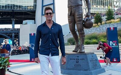 Tom Brady stands beside his new 12ft statue at Gillette Stadium, wearing a ‘Stand Up to Jewish Hate’ pin