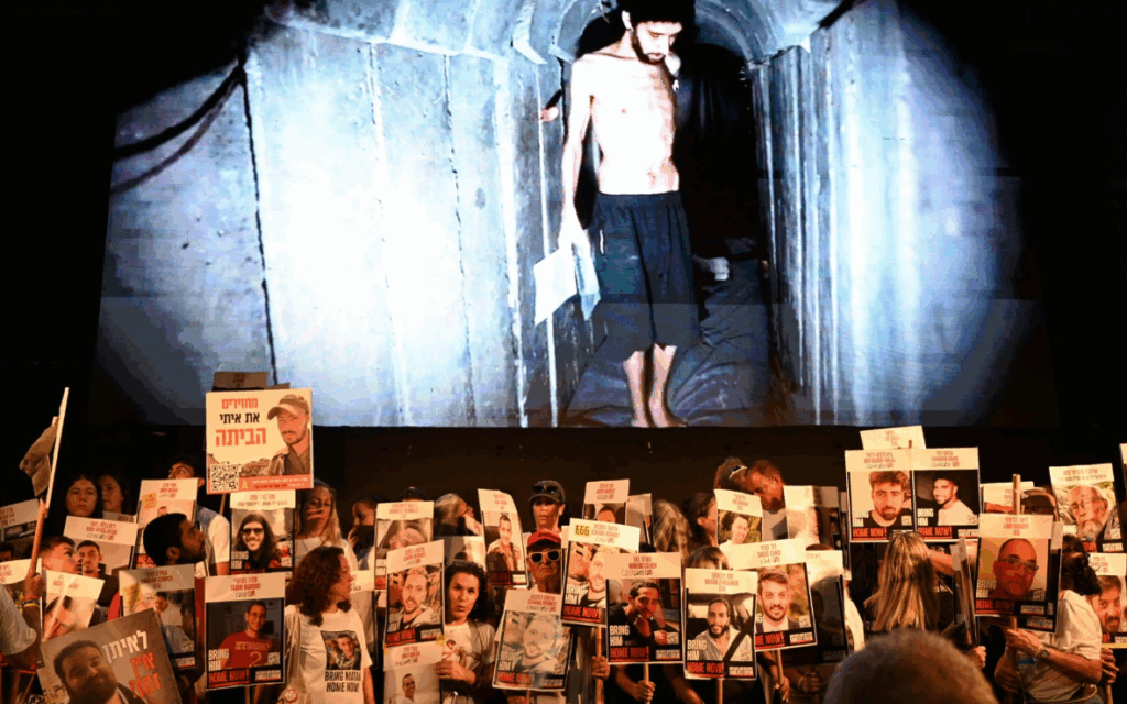 An image of Evyatar David from Hamas's latest propaganda video, behind some of those at last night's vigil (Credit: Paulina Patimer)