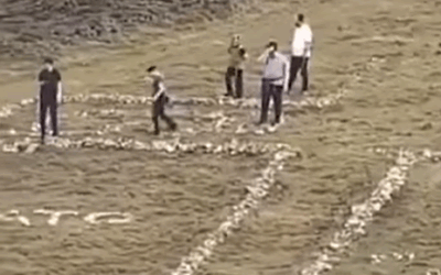 The Charedi tourists in the process of dismantling a cross (Facebook)