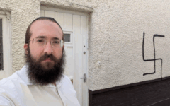 Rabbi Alperowitz next to the Nazi symbol daubed on his home