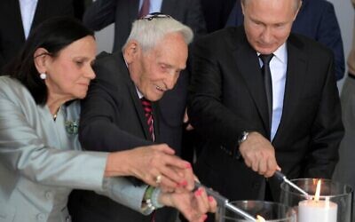 Russian President Vladimir Putin, right, and Aron Bell, center, light candles at an unveiling ceremony of a monument to the Heroes of Resistance at Nazi concentration camps and Jewish ghettos during the World War II, at the Jewish Museum and Tolerance Center in Moscow, Russia, June 4, 2019. (Alexei Druzhinin, Sputnik, Kremlin Pool Photo via AP)
