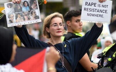 Karoline Preisler holds up signs at a Berlin protest, calling for justice for Israeli women and hostages.