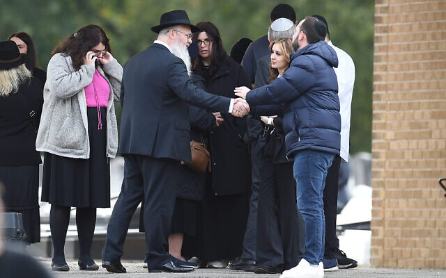 Rabbi Daniel Walker shakes hands with members of the congregation after the funeral of Adrian Daulby at Agecroft Jewish Cemetery in Salford, Manchester.