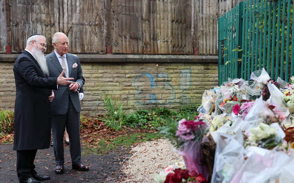 King Charles III and Rabbi Daniel Walker look at floral tributes during his visit to Heaton Park Hebrew Congregation Synagogue in Manchester, to meet members of the community, including some of those who were present during the October 2nd attack. Picture date: Monday October 20, 2025. PA Photo. Photo credit should read: Chris Jackson/PA Wire