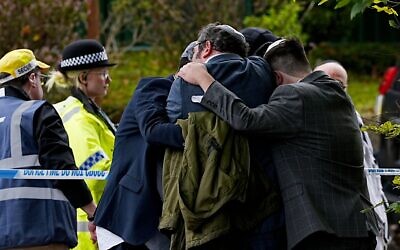 Members of the Jewish community comfort each other near to the Heaton Park Hebrew Congregation synagogue in Crumpsall, Manchester