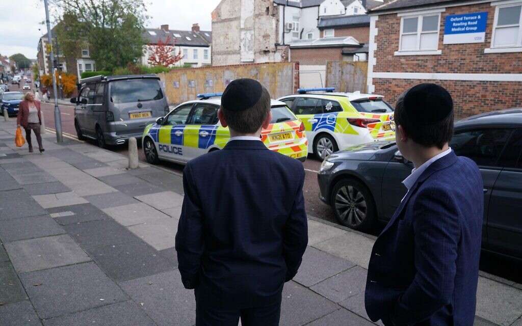 Young members of the Jewish community look at police cars close to the synagogues on Bewick Road in Gateshead. Prime Minister Sir Keir Starmer has said "additional police assets" will be deployed at synagogues across the country after two people died in a suspected terror attack by a man who was shot dead by police at Heaton Park Hebrew Congregation synagogue in Manchester. Picture date: Thursday October 2, 2025.