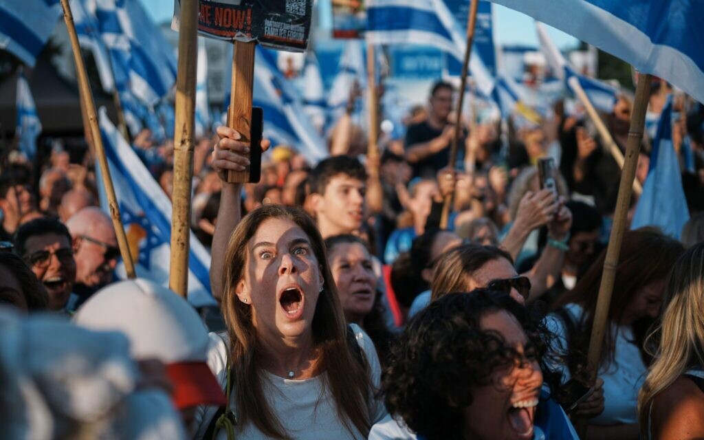People react as they gather to watch a live broadcast of Israeli hostages released from Gaza at a plaza known as hostages square in Tel Aviv, Israel, Monday, Oct. 13, 2025. The release took place as part of a cease-fire agreement between Israel and Hamas. (AP Photo/Emilio Morenatti)