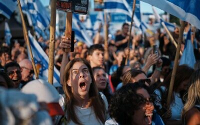 People react as they gather to watch a live broadcast of Israeli hostages released from Gaza at a plaza known as hostages square in Tel Aviv, Israel, Monday, Oct. 13, 2025. The release took place as part of a cease-fire agreement between Israel and Hamas. (AP Photo/Emilio Morenatti)