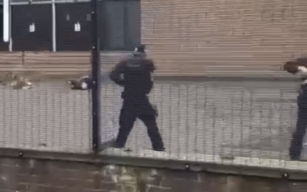 Screenshot of footage showing armed police on the scene.