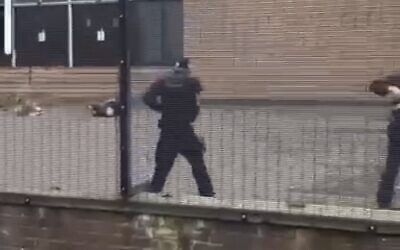 Screenshot of footage showing armed police on the scene.