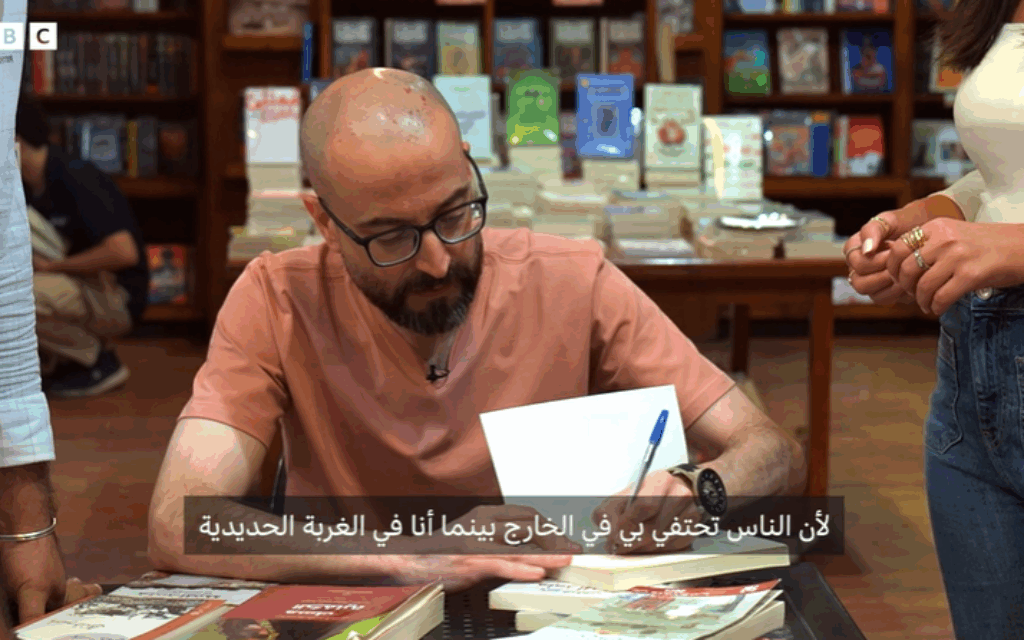 The BBC Arabic interview with Khandaqji features him signing copies of his latest book, "The Holocaust Custodian"