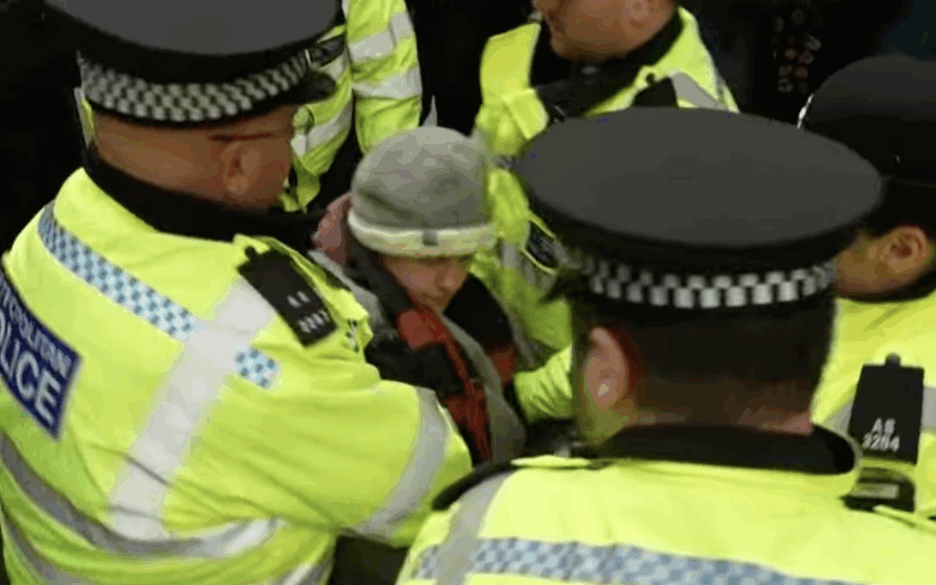Police officers remove a demonstrator outside the Ministry of Justice during a protest in support of the banned group Palestine Action. Credit: Dawn News