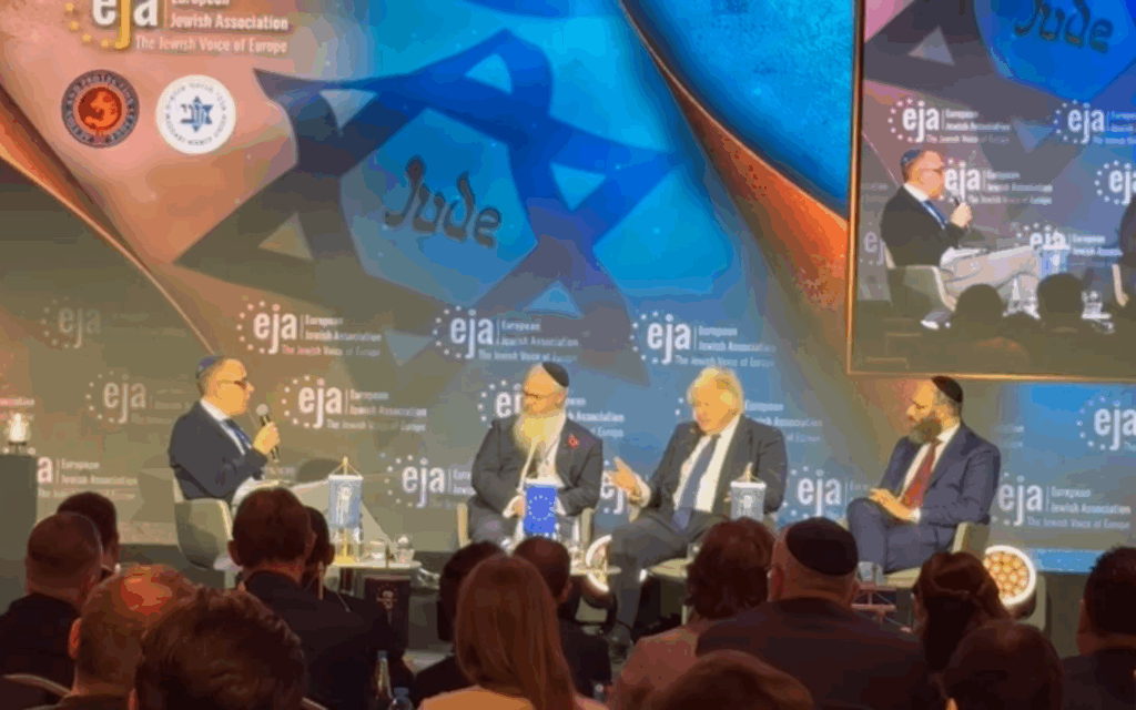 Manchester Rabbi Daniel Walker speaking alongisde Boris Johnson in Poland on Monday