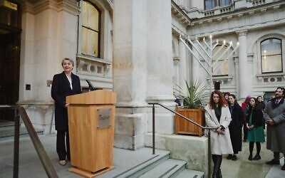 Yvette Cooper speaks at FCDO with Chanukiah in courtyard
