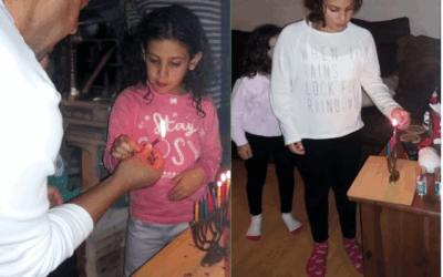 Eli Sharabi lights Chanukah candles with daughter Yahel and (rightI her older sister Noiya. The sisters were murdered on October 7 with their mother Lianne