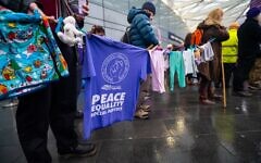Supporters of Friends of Standing Together display children’s clothing and peace messages during the Human Rights Day vigil at King’s Cross. Credit:
Abraham Dein