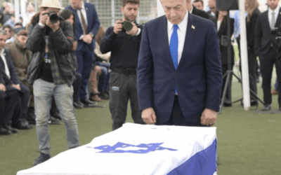 Prime Minister Benjamin Netanyahu stands beside the flag-draped coffin of Ran Gvili at his funeral in Meitar on January 28, 2026. Credit:
X / GPO