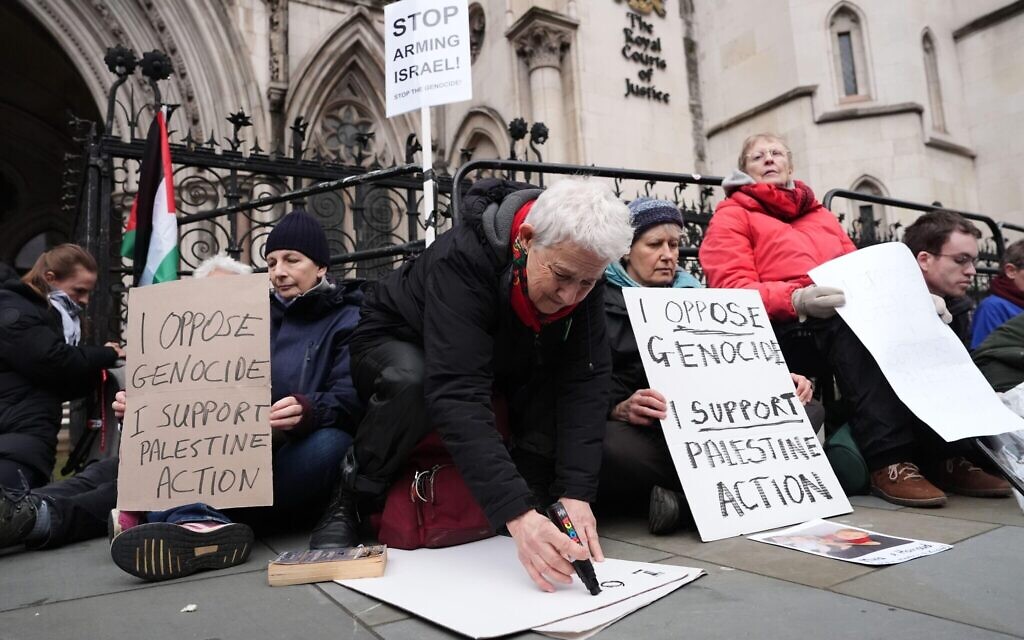 Protesters write on placards outside the High Court, central London. Picture date: Friday February 13, 2026.