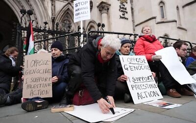 Protesters write on placards outside the High Court, central London. Picture date: Friday February 13, 2026.