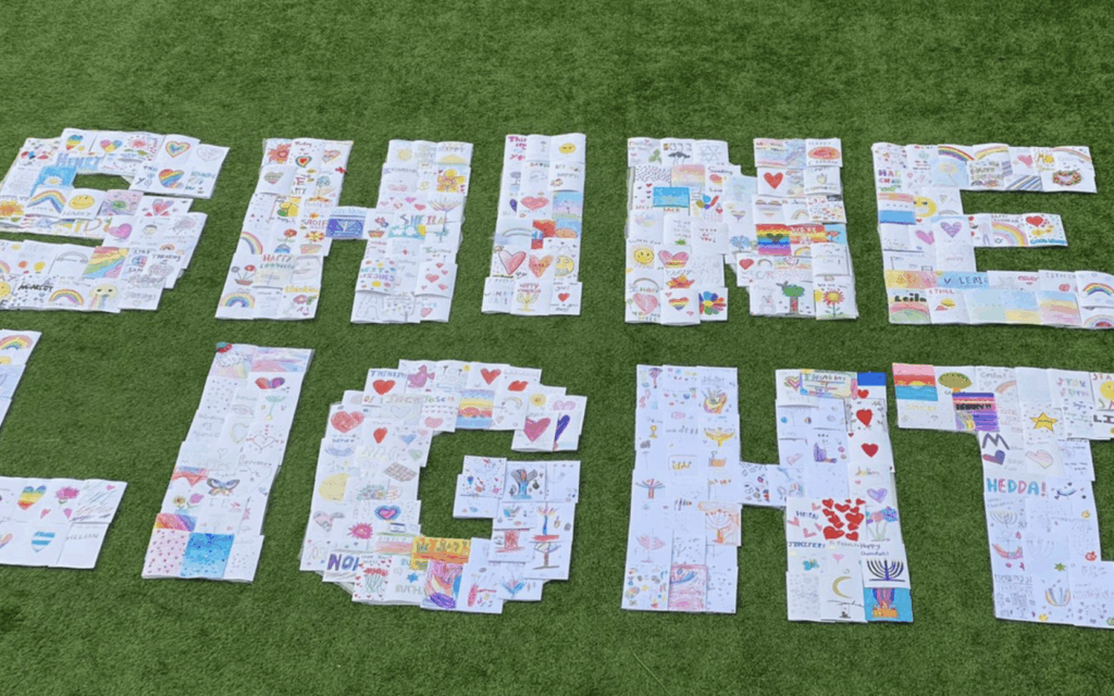 Handwritten cards of care arranged to spell ‘Shine Light’, reflecting the message behind a UK-led initiative supporting hostages, wounded soldiers and bereaved families in Israel.