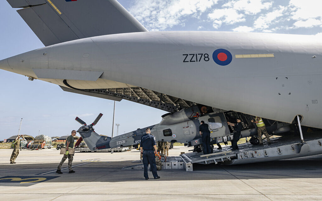 A Royal Navy Wildcat HMA Mk2 (HMA2) being unloaded from an RAF C-17, by RAF movers and RN personnel, at a British base in Cyprus.