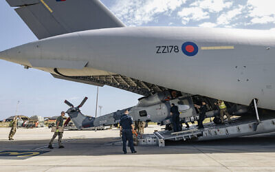A Royal Navy Wildcat HMA Mk2 (HMA2) being unloaded from an RAF C-17, by RAF movers and RN personnel, at a British base in Cyprus.