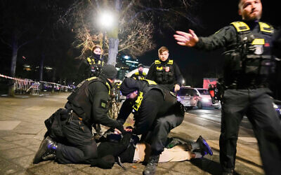 Police officers detain a man at the Holocaust memorial in Berlin, Germany, after another man was seriously injured, February 21, 2025. (Ebrahim Noroozi/AP via Times of Israel)