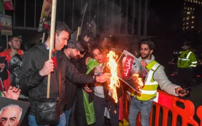 Counter protesters light a picture of the Ayatollah Ali Khamenei on fire in Manchester. Pic: PA