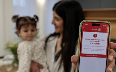 A woman shows a missile alert notification on her mobile phone as residents take cover indoors following missile fire from Iran toward Israel on the eve of the Passover, in Mishmar David, 1 April 2026. (Nati Shohat/Flash90)