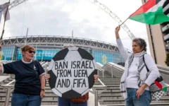 Pro-Palestinian activists protest with a football-shaped sign and a Palestinian flag outside Wembley Stadium to demand that the Football Association issue a public statement calling for the Israeli Football Association (IFA) to be suspended from participation in UEFA and FIFA tournaments, on October 2, 2025 in London, United Kingdom. (Mark Kerrison/In Pictures via Getty Images via JTA)