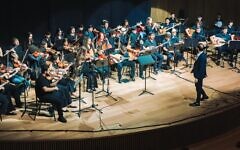 Tom Cohen conducts the youth program of The Jerusalem Orchestra East & West in Tel Aviv, May 2026. (Yaakov Buta)
