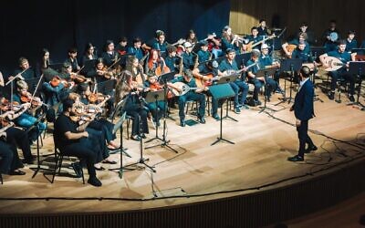 Tom Cohen conducts the youth program of The Jerusalem Orchestra East & West in Tel Aviv, May 2026. (Yaakov Buta)