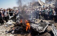 20th July, 2026. Palestinians stand around a burned vehicle following an Israeli drone strike in Gaza City, on July 20, 2026. A drone struck a civilian vehicle in central Gaza City, targeting one of the leaders of the 7 October attack.