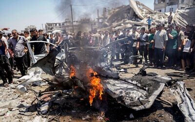 20th July, 2026. Palestinians stand around a burned vehicle following an Israeli drone strike in Gaza City, on July 20, 2026. A drone struck a civilian vehicle in central Gaza City, targeting one of the leaders of the 7 October attack.