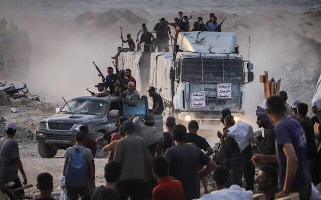 Armed Palestinians sit on trucks carrying humanitarian aid near the Zikim border crossing between Israel and Beit Lahia in the northern Gaza Strip, Aug. 18, 2025. Photo by Khalil Kahlout/Flash90 via JNS