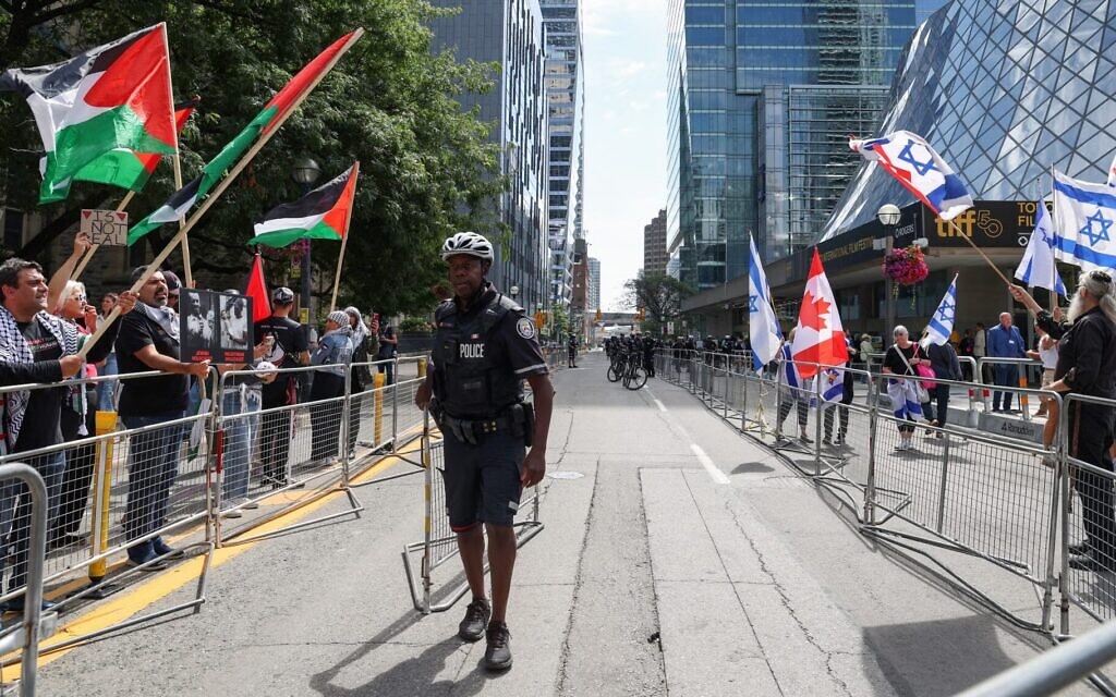 Pro-Palestinian and pro-Israel demonstrators rally on opposite sides of the street in front of the Roy Thompson Hall, where the documentary “The Road Between Us: The Ultimate Rescue” is showing, during the Toronto International Film Festival (TIFF) in Toronto, Ontario, Canada, on September 10, 2025. (Photo by Valerie Macon/ AFP)