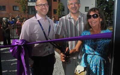Marcia Brown cuts the ribbon to open LJHA’s new affordable homes development, watched by the association’s Director of Operations Craig Simons (left) and Chair of the Board Andrew Pliener