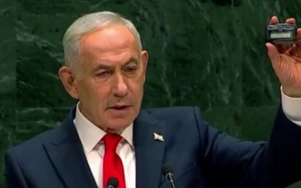 Benjamin Netanyahu holds a pager during his speech while discussing Israel's targeted attacks on Hezbollah.
