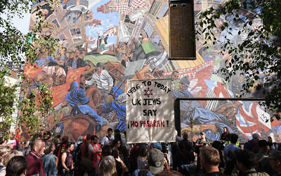 People march past the 'Cable Street' mural in Whitechapel, east London, to mark the 90th anniversary of the Battle of Cable Street, a huge demonstration in 1936 to block Oswald Mosley and his Blackshirts from marching through the East End of London. Organisers said the so-called Battle of Cable Street was a massive moment in history, when ordinary men, women, and children, stood shoulder to shoulder saying that organised fascists would not march through their community. Picture date: Sunday October 4, 2026.Photo credit: Aaron Chown/PA Wire