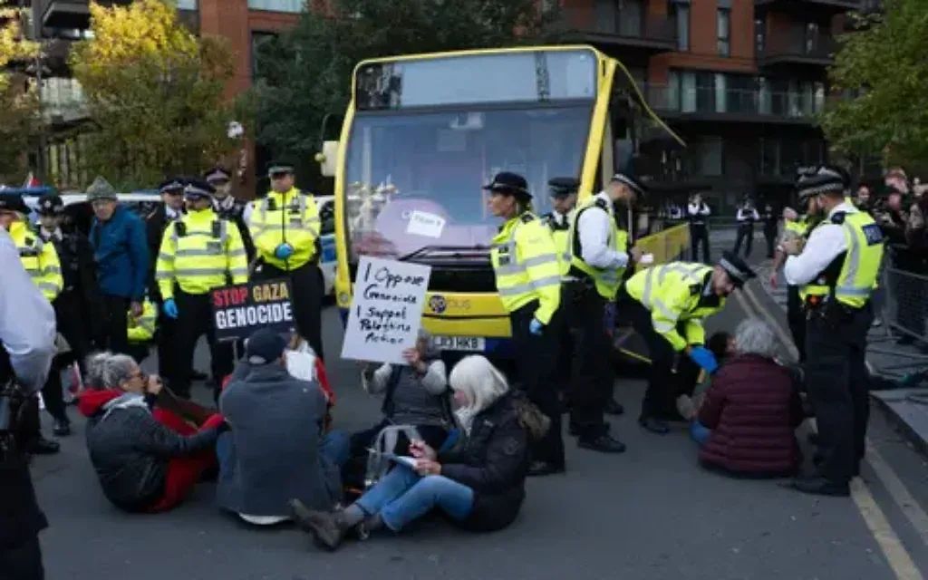 Protesters sit down in front of a police bus as they take part in a protest organised by Defend Our Juries outside the US embassy in south London in support of Palestine Action  Pic PA 
Marcin Calak