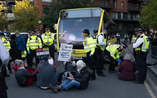 Protesters sit down in front of a police bus as they take part in a protest organised by Defend Our Juries outside the US embassy in south London in support of Palestine Action  Pic PA 
Marcin Calak