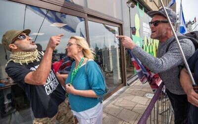 A Green party attendee is restrained from exchange of views with a pro Israel supporter during the demonstration.