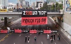 Banner reads: "Three years after the massacre, we remember those murdered and wounded on Oct 7. On October 27, Election Day, we will ensure a commission of inquiry and repair." Ayalon Highway, Tel Aviv, October 7, 2026