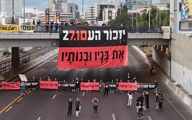 Banner reads: "Three years after the massacre, we remember those murdered and wounded on Oct 7. On October 27, Election Day, we will ensure a commission of inquiry and repair." Ayalon Highway, Tel Aviv, October 7, 2026