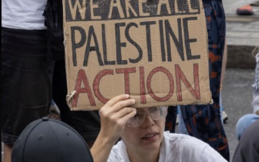 A demonstrator holds a placard reading “We Are All Palestine Action” during a protest against the group’s proscription.